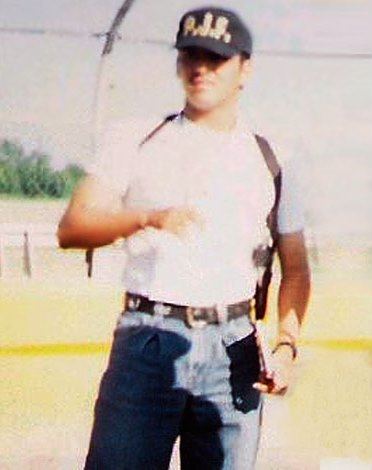 Arturo Guzmán Decena wearing a cap, a white shirt, and blue jeans.