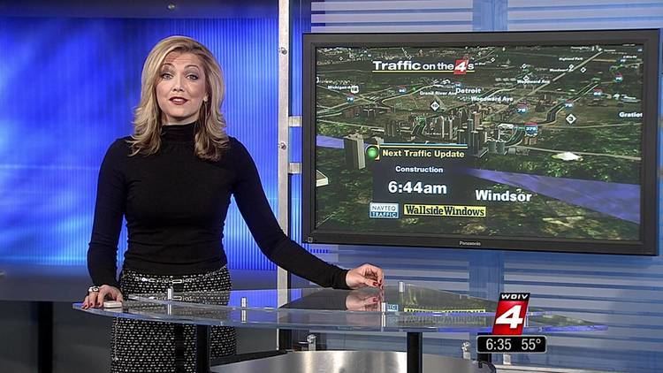 Ashlee Baracy as morning traffic reporter while wearing a black long sleeve blouse and black and white skirt