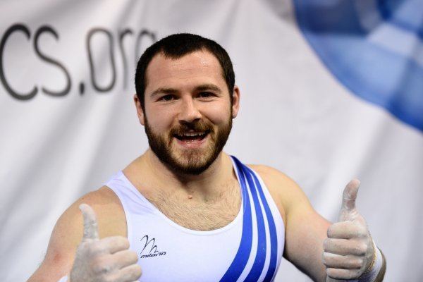 Ashley Watson smiling while giving a thumbs up and wearing a white and blue sando