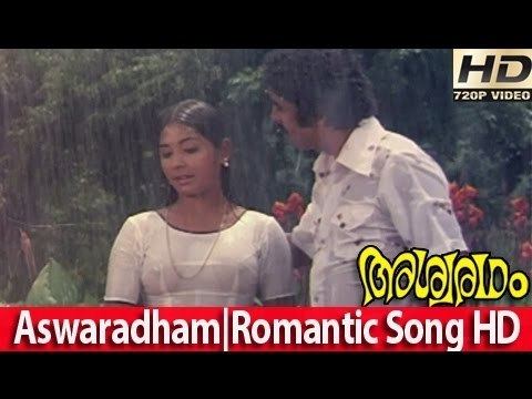 Srividya bathing in the rain while wearing a white dress and Raveendran wearing white long sleeves in the music video of the 1980 film, Ashwaradham