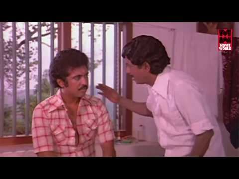 Raveendran talking to a man while he is wearing a white long sleeves in a scene from the 1980 film, Ashwaradham