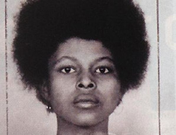 Assata Shakur with a serious face and kinky hair.