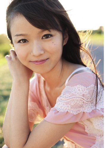 Asuka Hoshino smiling and wearing a pink dress with white lace.