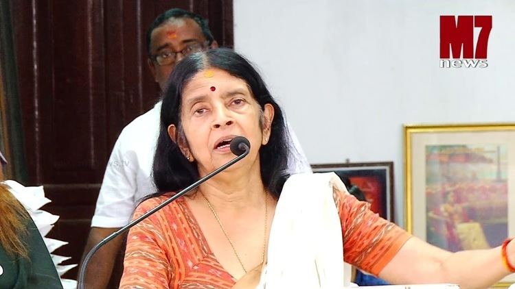 Aswathi Thirunal Gowri Lakshmi Bayi giving a speech while wearing a white and orange dress