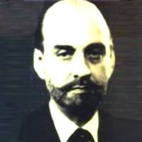 Sardar Ataullah Mengal with beard and mustache while wearing a black coat, white long sleeves and necktie