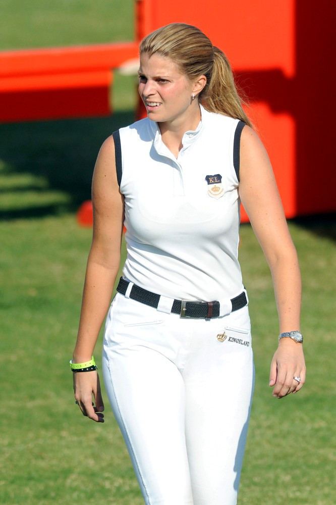 Athina Onassis Roussel wearing black and white sleeveless polo, black belt and white pants