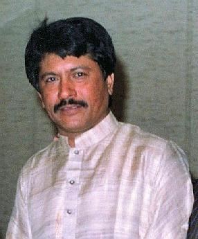 Attaullah Khan Esakhelvi smiling with mustache while wearing a white long sleeves