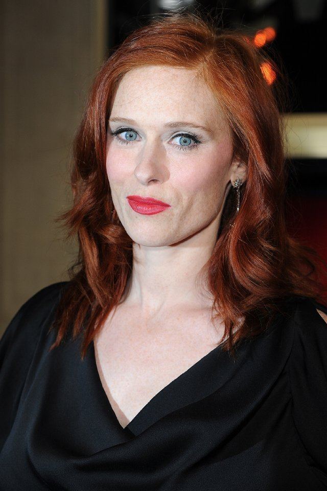 Audrey Fleurot on her reddish-brown color hair wearing black shirt and pair of earrings