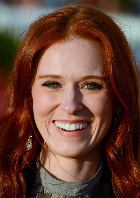 Audrey Fleurot smiles while wearing a gray shirt and earrings (a closed up photo)