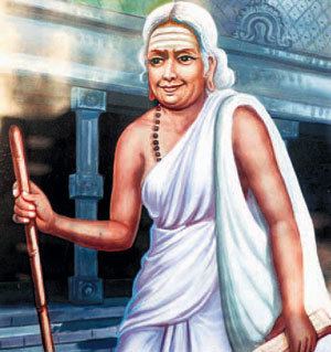 Avvaiyar smiling while carrying a white bag and wearing a white dress and necklace