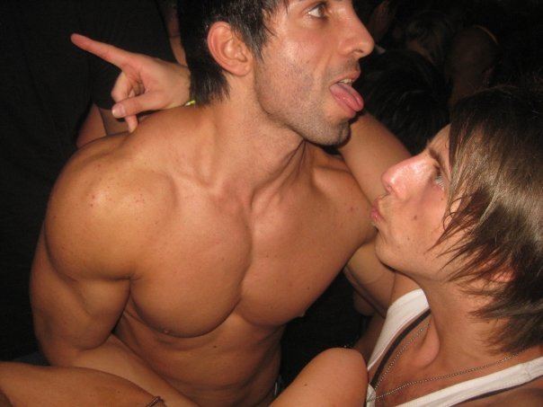 Aziz Shavershian is topless with a man wearing a white sleeveless shirt.