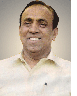 B. Ravi Pillai smiling while wearing a cream polo