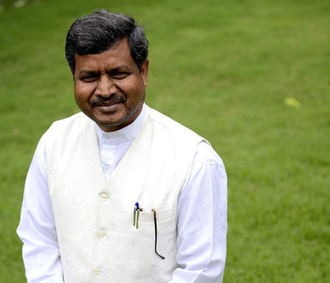 Babulal Marandi, Former Chief Minister of Jharkhand is smiling, has black white hair, a beard, and a mustache, has a blue and black pen in his left pocket and black eyeglasses, he is wearing white long sleeves under a white vest.