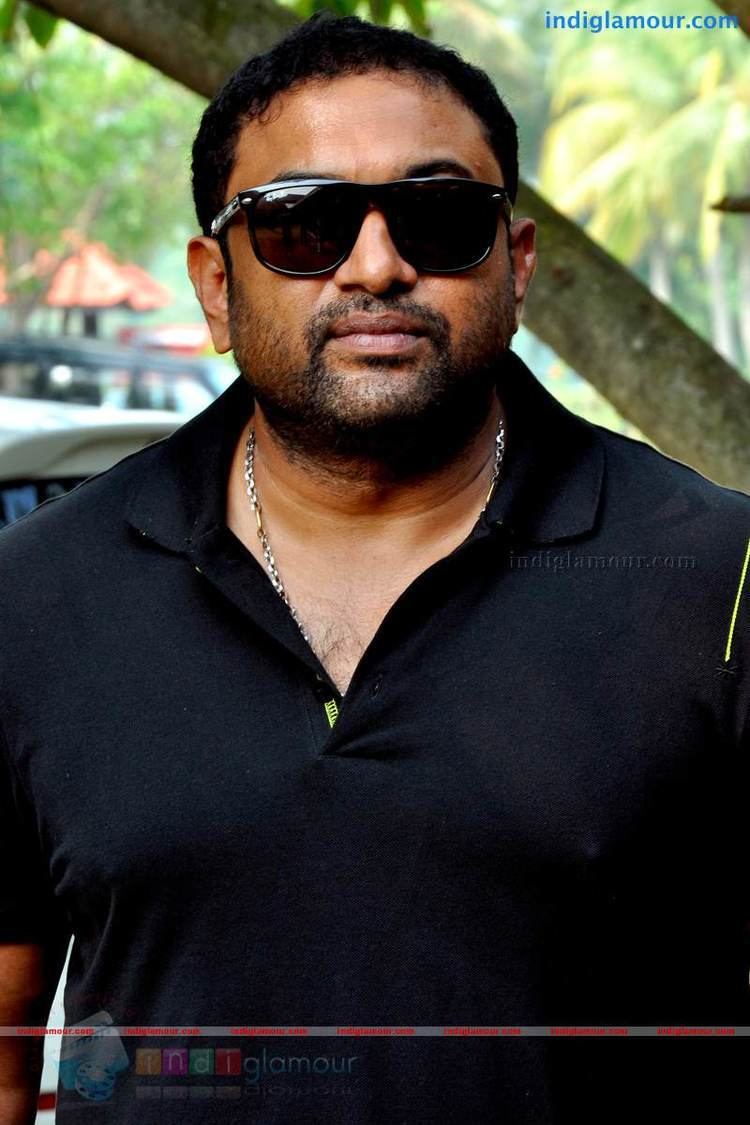 Baburaj wearing black shades and black polo shirt