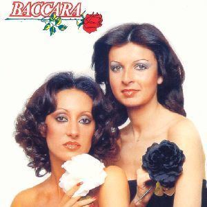 María Mendiola of the Baccara vocal duo is holding a white flower while Mayte Mateos holding a black flower and wearing a black tube top