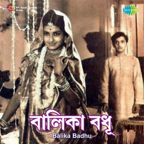 Moushumi Chatterjee smiling while Partho Mukerjee looking at her in a scene from the 1967 Bengali film, Balika Badhu