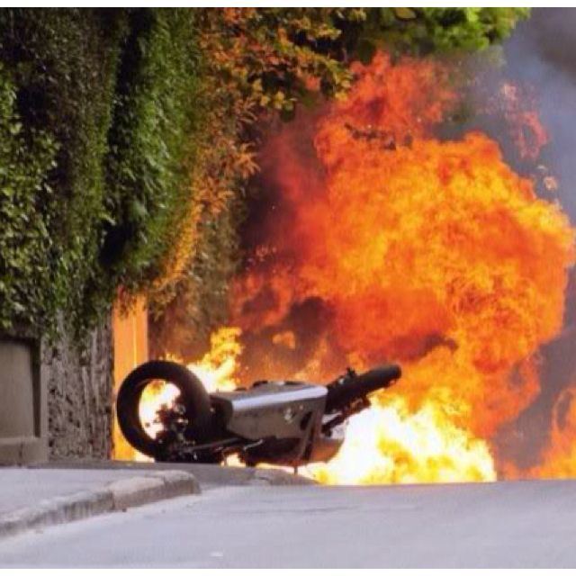 Captured a motorbike is lying on the road with a big fire at a high-speed crash at the Isle of Man TT races