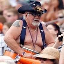 DENVER, CO - NOVEMBER 14: A performer in an inflatable costume resembling  late Broncos fan Tim McKernan, also known as Barrel Man, prepares to go  onto the field with servicemen and women