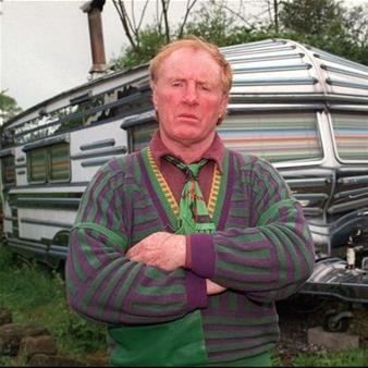 Bartley Gorman looking serious while standing and wearing a red sleeve and green jacket