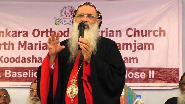 Baselios Mar Thoma Paulose II giving a speech while wearing a black and red cassock, necklaces and eyeglasses
