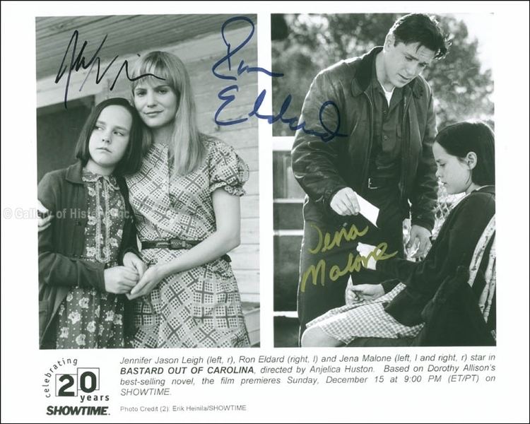 A photograph showing snippets in a scene from the 1996 American drama film, Bastard Out of Carolina with signatures on it. On the left are Jena Malone and Jennifer Jason Leigh smiling with serious faces, standing while Jennifer's right arm is hugging Jena's waist while Jena's hands are on Jennifer's left hand. With a house in the background, Jena has short hair, wearing a blue collared dress with prints, and a black long sleeve blazer. Jennifer has long blonde hair wearing a belt on her printed puffed-sleeve dress. On the right Ron Eldard and Jena Malone where Ron is standing, talking and giving out a piece of paper to Jena who is sitting on a chair. Ron has short black hair wearing a black belt, a pair of pants, a leather jacket with a white shirt, and a collared shirt underneath; while Jena has short hair tucked in her ear, wearing a black long sleeve blazer over a checkered dress.