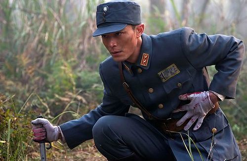 Wallace Huo with blood on his stomach while holding a knife and wearing a uniform in a movie scene from Battle of Changsha (2014 Chinese TV Drama series).