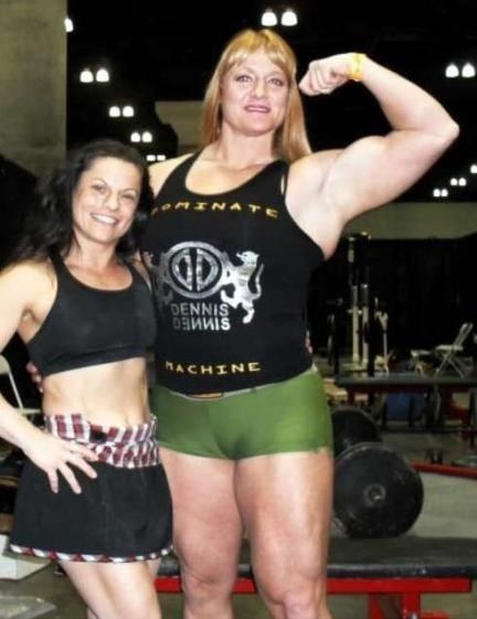 Becca Swanson smiling while wearing a black sleeveless top and green shorts and the woman beside her wearing a black top and black shorts