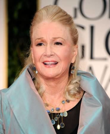 Belinda Montgomery smiling while wearing a gray dress with black inner top and some pieces of jewelry