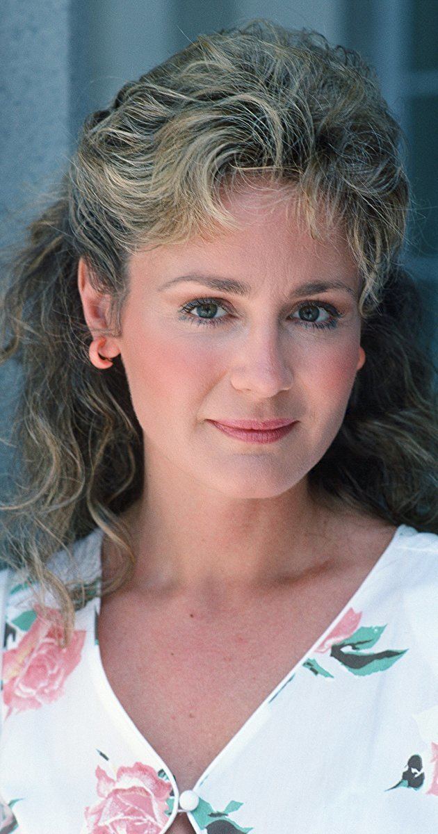 Belinda Montgomery smiling while wearing a white and pink floral blouse