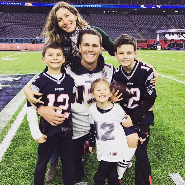 Gisele Bundchen, Benjamin Rein Brady, Tom Brady, John Edward Thomas Moynahan, and Vivian Lake Brady are smiling together while they are at the football field