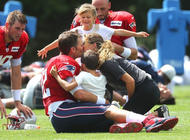 Tom Brady, Gisele Bundchen, Benjamin Rein Brady, and Vivian Lake Brady in a family group hug during the Patriots practice session