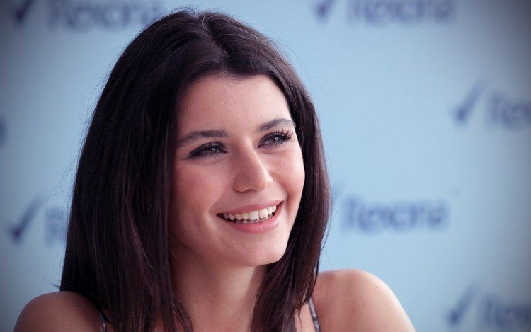 Beren Saat smiling while being interviewed with her hair being straight.