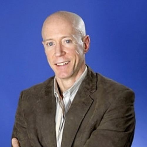 Bernard McGuirk with a bald head, wearing a gray suit.
