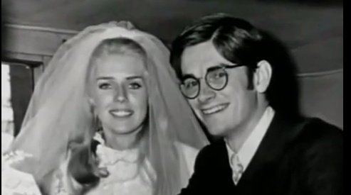 Betty Broderick wearing a white gown with a veil on her head and  Daniel T. Broderick III wearing a suit and eyeglasses during their wedding.