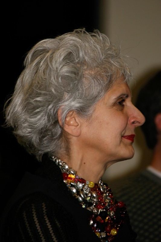 Beverly Donofrio smiling while looking afar and wearing necklaces and a black blouse
