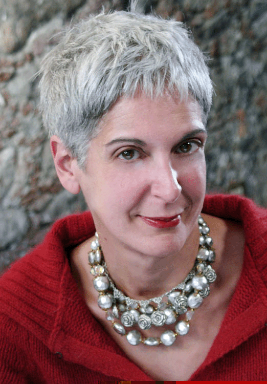 Beverly Donofrio with a tight-lipped smile while wearing a red blouse and gray necklace