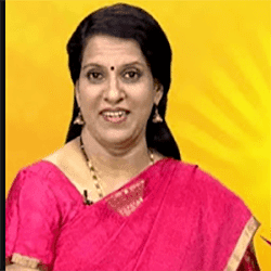 Bharathi Baskar smiling while wearing a pink and gold dress, earrings, and necklace