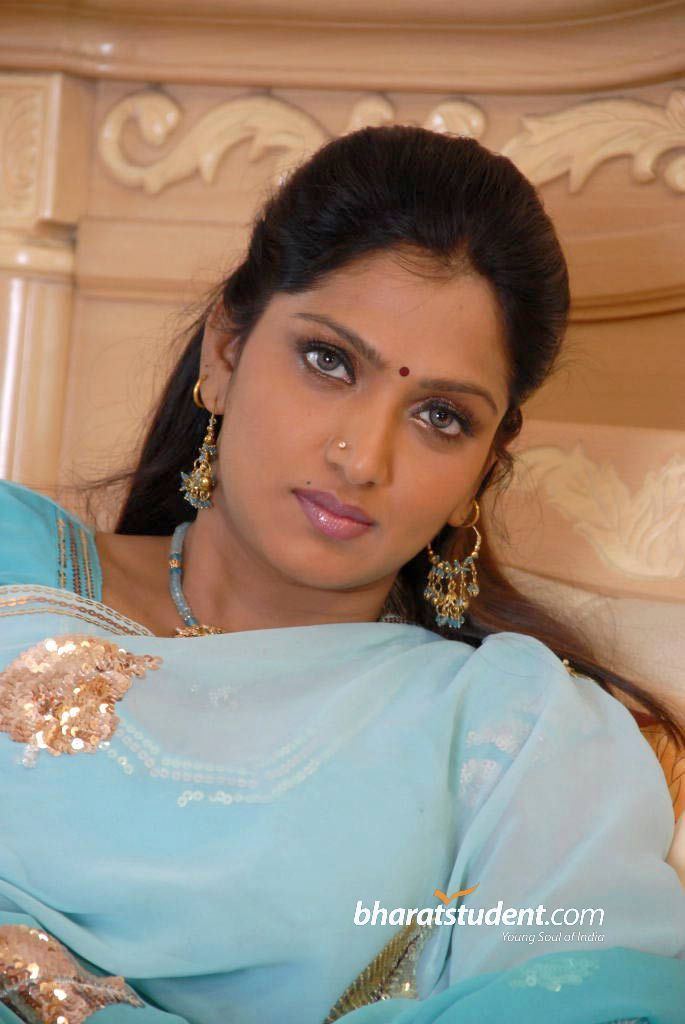 Bhuvaneswari wearing a sky-blue dress with gold sequin, blue necklace, nose-jewel, and earrings
