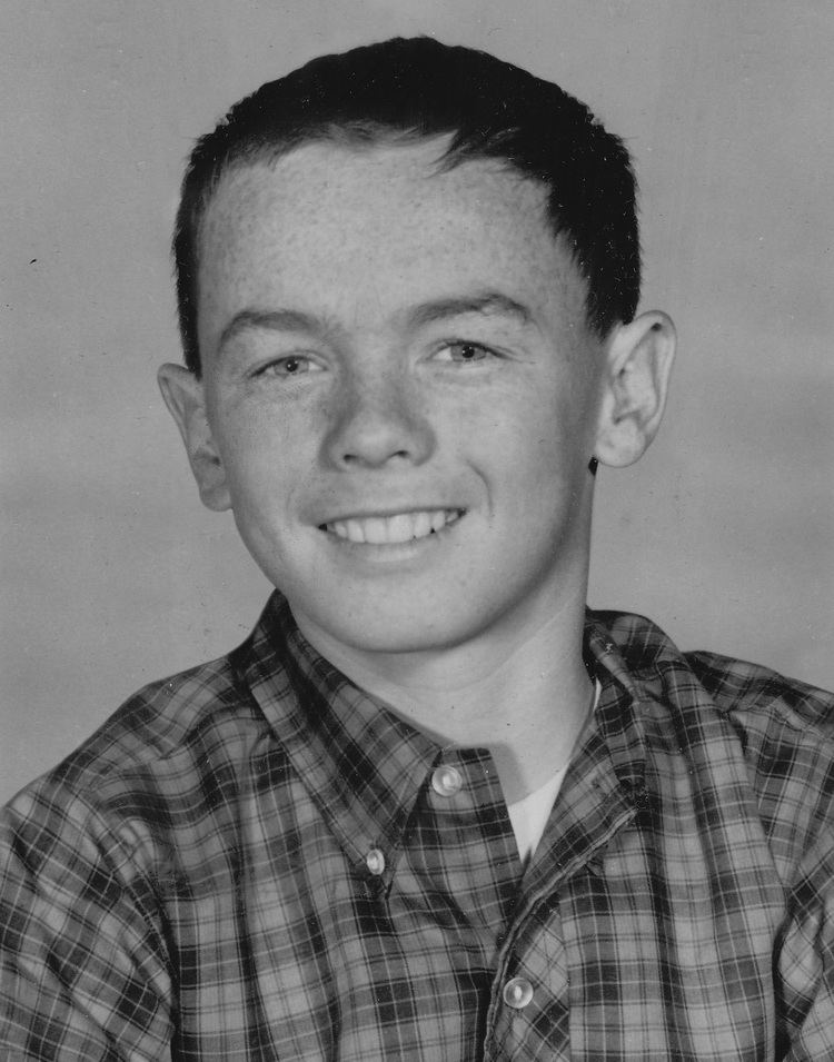 Billy Booth smiling while wearing a checkered polo