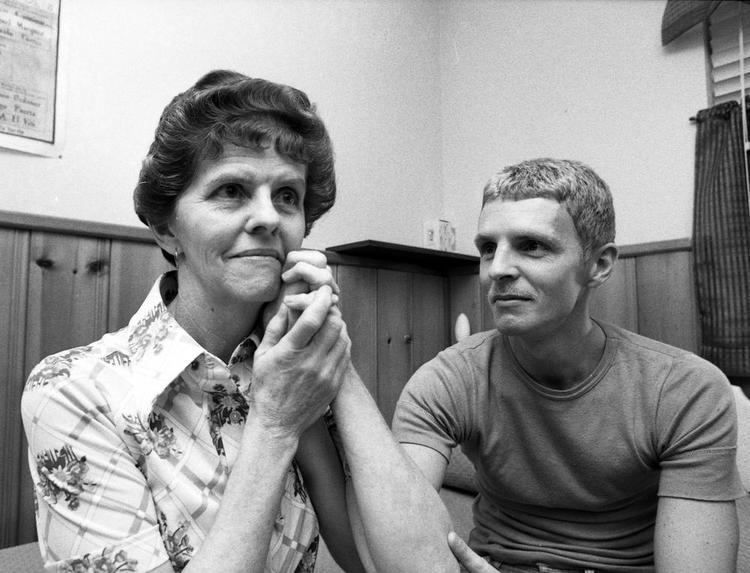 Dorothy Hayes holding Billy Hayes' hand while she is wearing a floral blouse