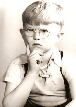 Billy Laughlin in 1941 while his hand on his chin and wearing a polo shirt