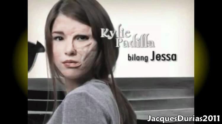 The movie scene of Blusang Itim (2011), Kylie Padilla is serious, has long black hair, inborn scar on left of her face wearing a gray top, at the right is her screen name “Kylie Padilla bilang Jessa” at the bottom right is a word "JacquesDurias2011"