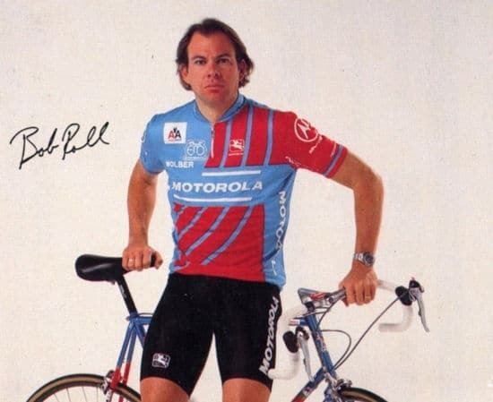 Bob Roll wearing a red and blue jersey and black biker shorts