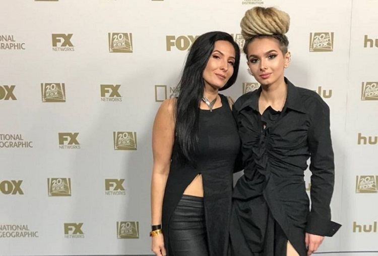 Bobbi Jo Black smiling in a black dress with her daughter Zhavia Ward in a black dress and hair in a bun