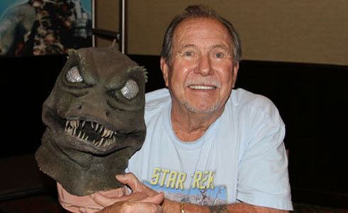 Bobby Clark smiling and holding The Gorn costume