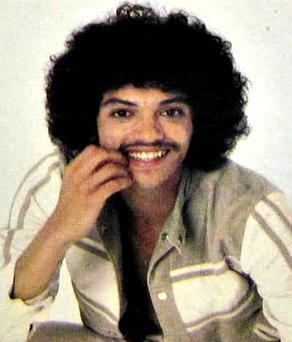 Bobby DeBarge smiling while wearing a white and brown long sleeves