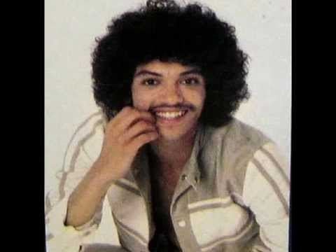 Bobby DeBarge smiling while wearing a white and brown long sleeves