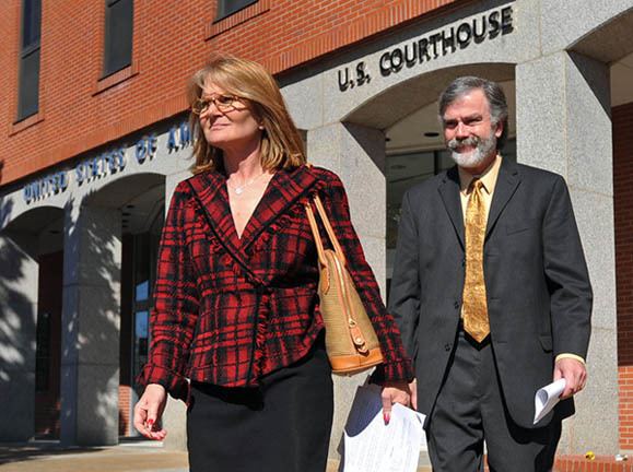 Bobby DeLaughter wearing gray coat, light yellow long sleeves and yellow neck tie while Cynthia Speetgens wearing black and red blouse