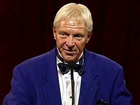 Bobby Heenan wearing a blue coat, white long sleeves, and a black bow tie