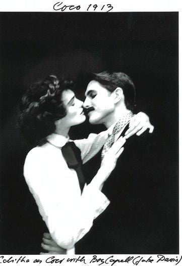 Coco Chanel and her lover Captain Arthur Edward "Boy" Capel kissing.  Coco wearing a white long sleeve blouse while Boy Capel wearing a black coat.